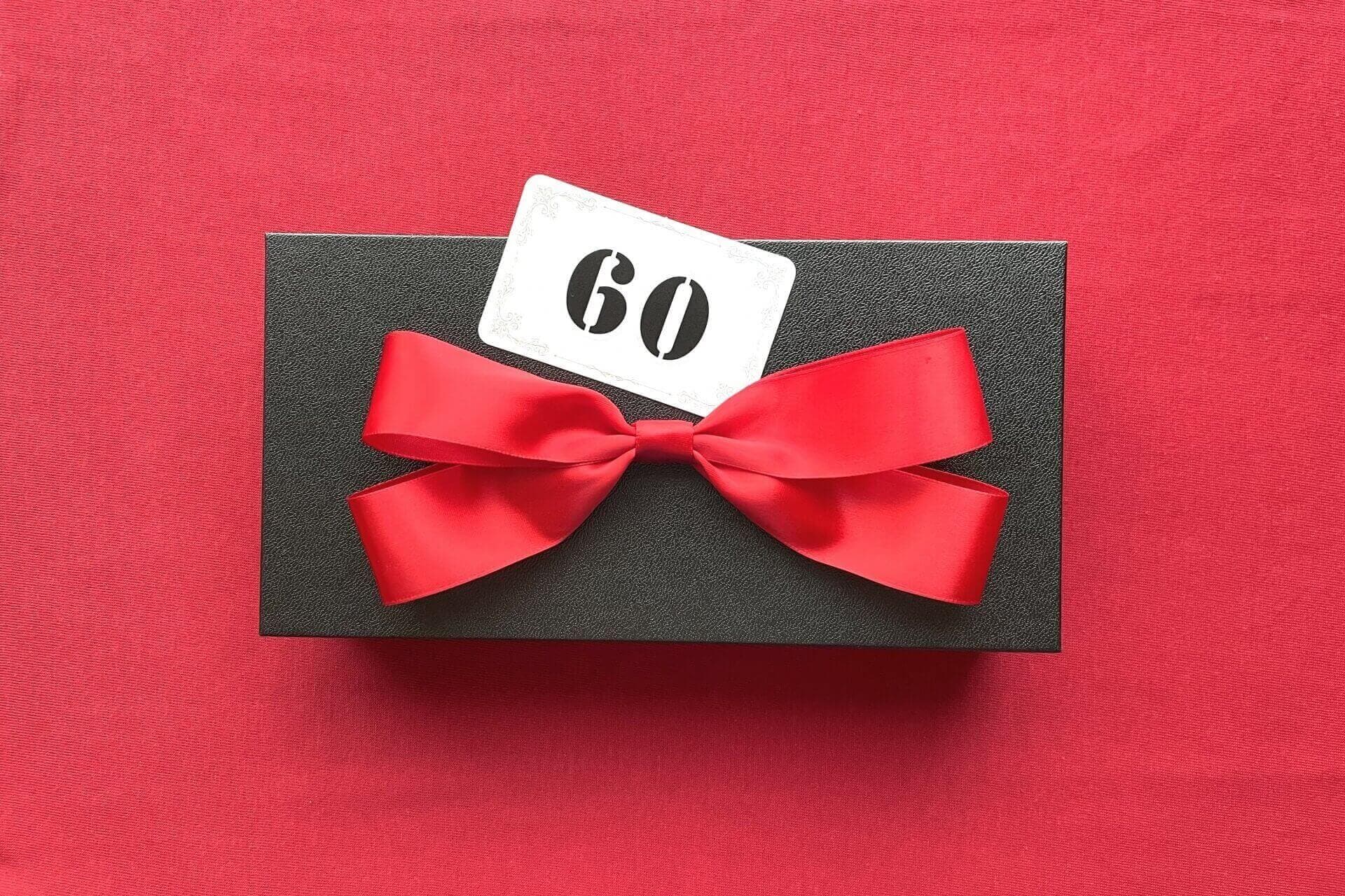 「60」と書かれたカードとリボンがつけられたギフト